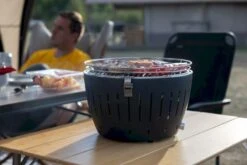 LotusGrill XL Hybrid Houtskoolbarbecue - Rood -Openlucht Kampeer Winkel lotusgrill in gebruik met toppy shirtje 2